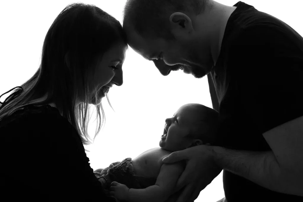 Silhouette des parents front contre front autour de leur nouveau-né, séance photo bébé en studio